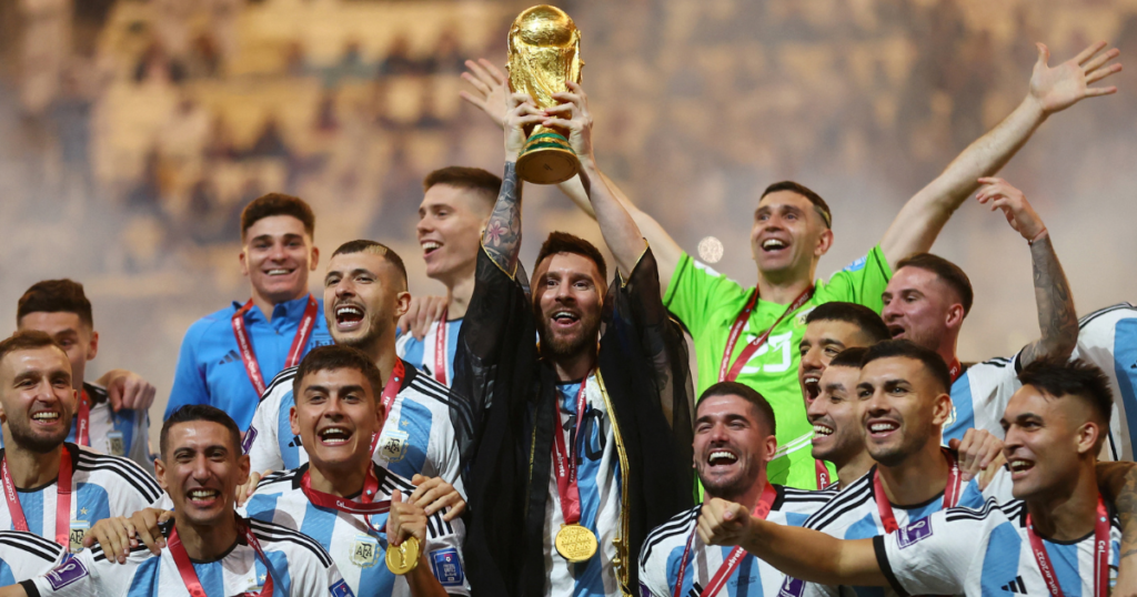 Lionel Messi along with other Argentinian players celebrating with the FIFA World Cup 2022 trophy.