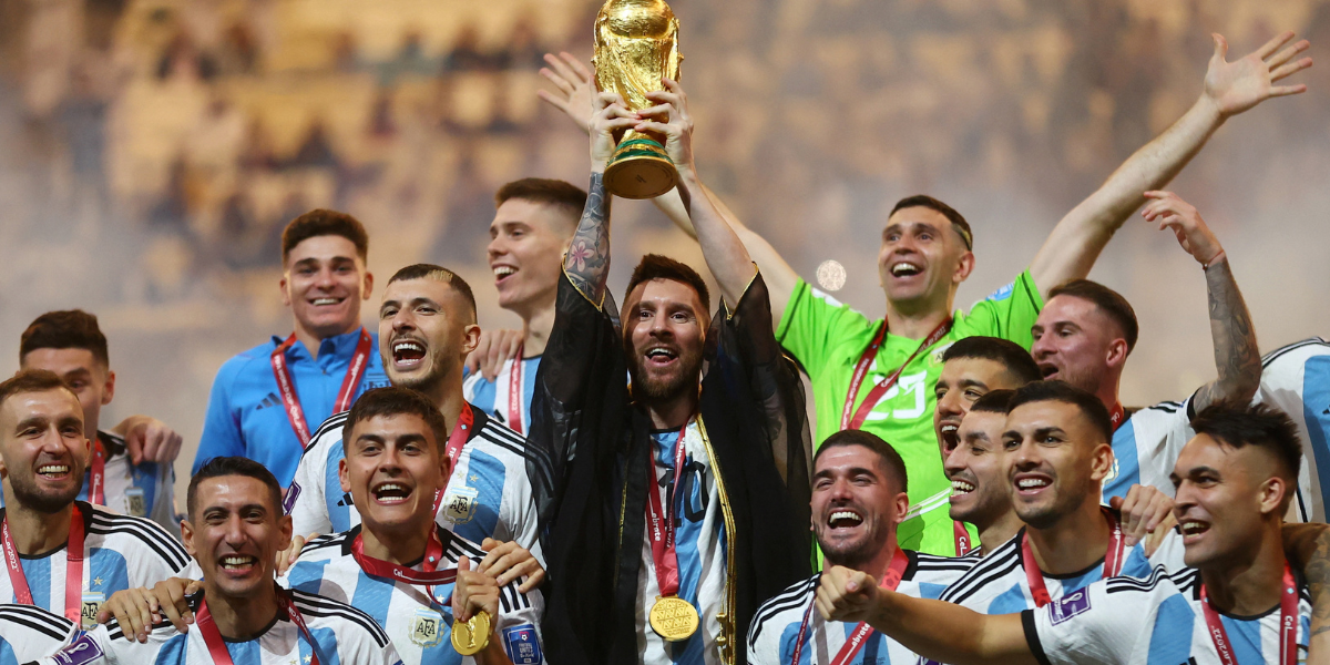 Lionel Messi along with other Argentinian players celebrating with the FIFA World Cup 2022 trophy.